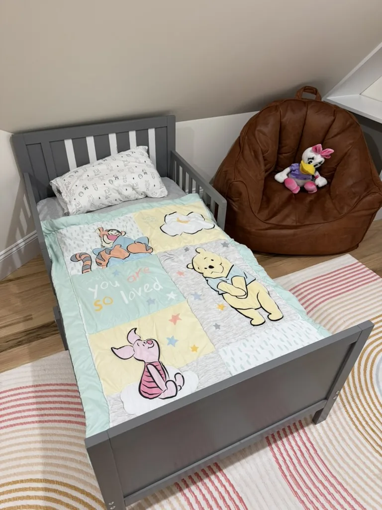 Toddler bed with soft bedding and a stuffed-animal corner